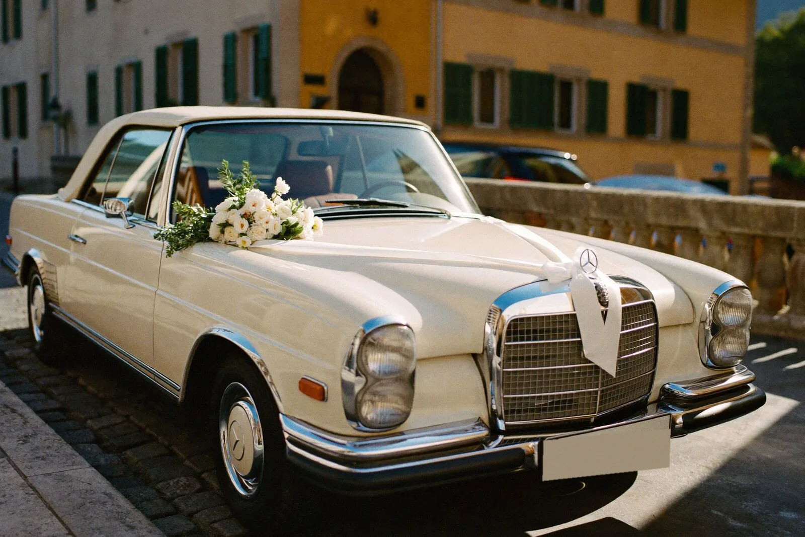 Auto d'epoca avorio fiorita per la partenza degli sposi